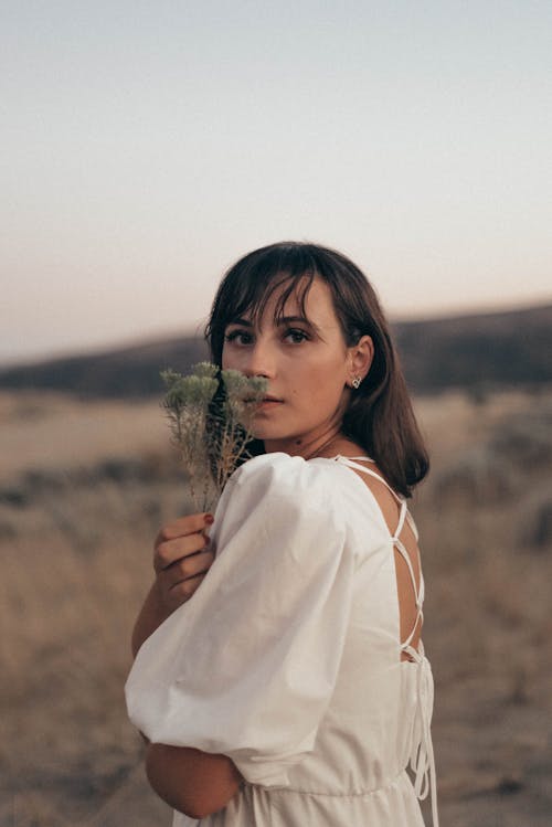 Dreamy woman with dried flower in nature