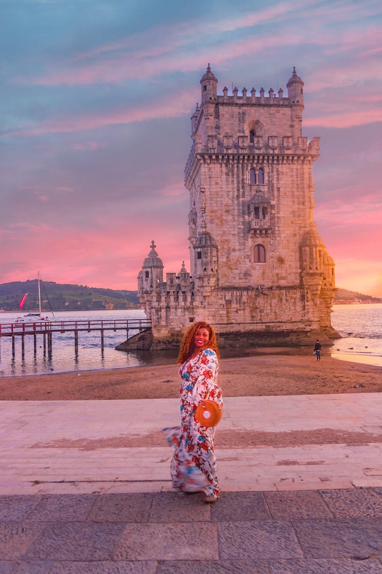 Woman Posing Near The Historical Belem Tower Of Lisbon During Sunset