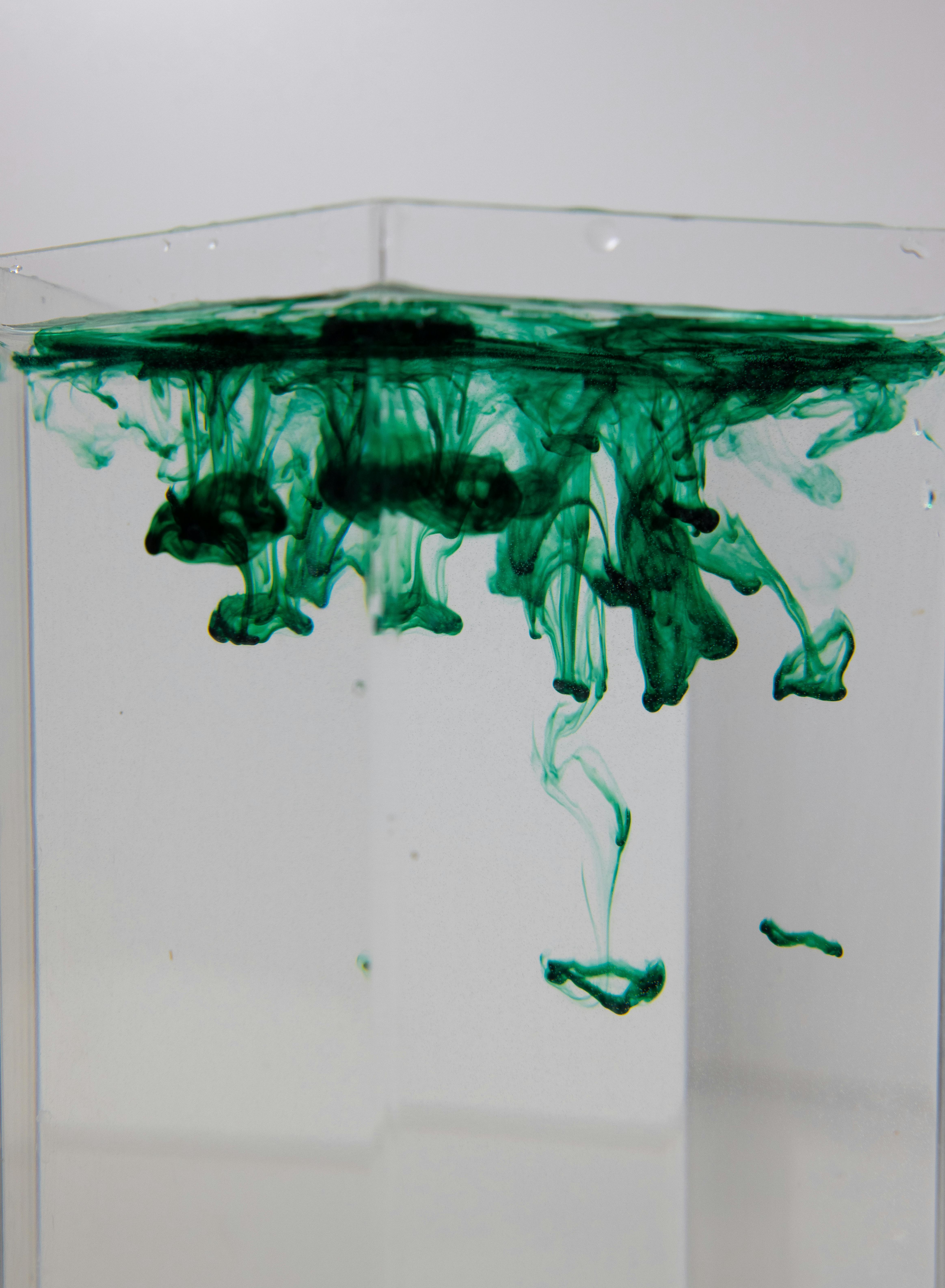glass with aqua and spreading paint flows
