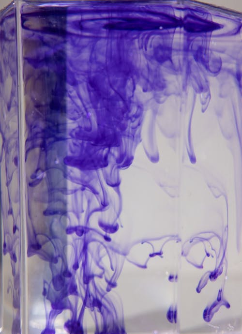 Vase with violet pigment streams in water
