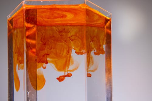 Glass with colorful ink flows in liquid