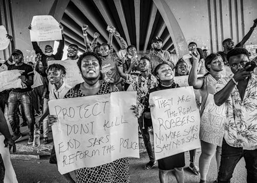 People Holding Banners while Protesting on the Street