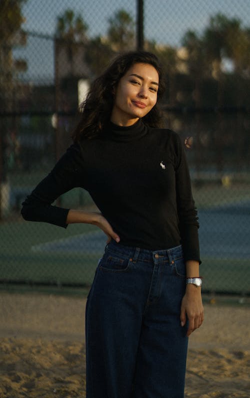 Confident woman standing in street near fence