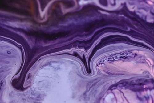 Free Close-up of vivid purple ink marbling creating intricate abstract patterns. Stock Photo
