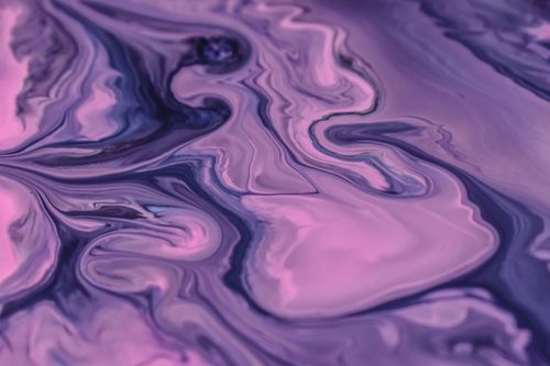 Free Close-up of vibrant purple and pink abstract paint swirls reminiscent of marbling. Stock Photo