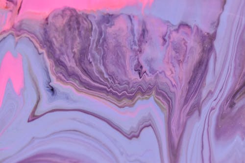 Abstract background of artwork representing pink and purple acrylic paint fluids with thin waves