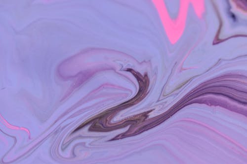 Abstract backdrop of artwork representing violet and pink watercolor fluids creating thin waves and swirls