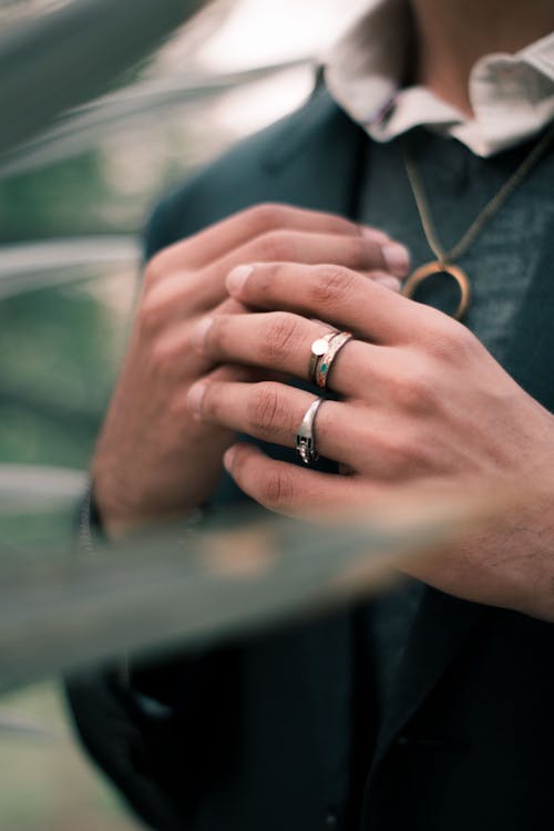 A Person in Suit Wearing Necklace and Rings 