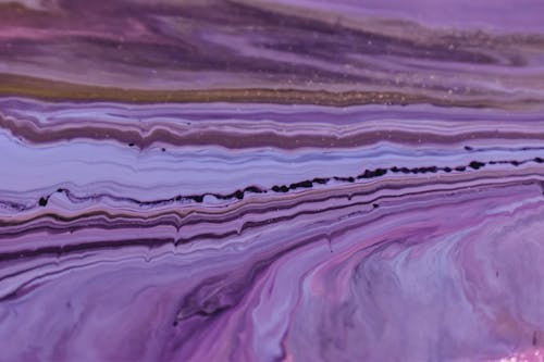 Abstract backdrop of artwork representing purple and brown dye flows with rows of bended lines