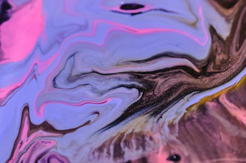 Full frame abstract background of spilled glossy blue and pink fluids dissolving on uneven surface