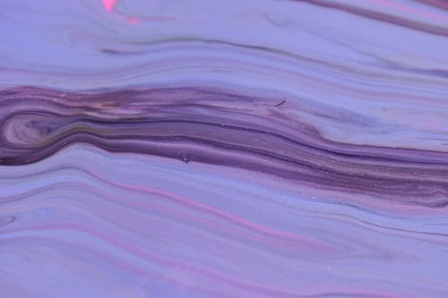 Purple paints spilled and flowing on uneven surface