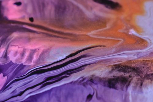 Free Full frame background of diffusing spilled blue pink and yellow fluids swirling and mixing Stock Photo