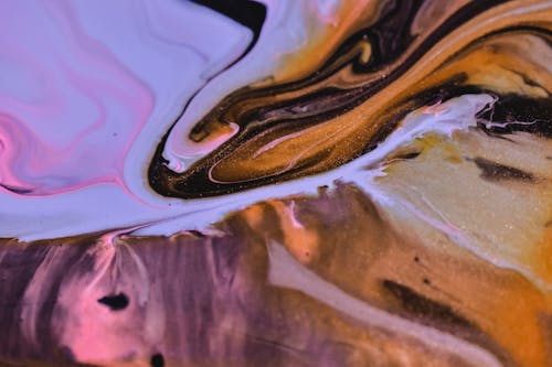 Full frame of smooth flowing paints of brown pink and blue colors mixing and dissolving