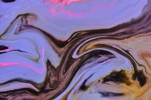 Mix of multicolored paints swirling on uneven surface