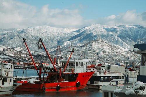 Bateau Rouge Et Blanc Sur Le Quai Près De La Montagne Couverte De Neige