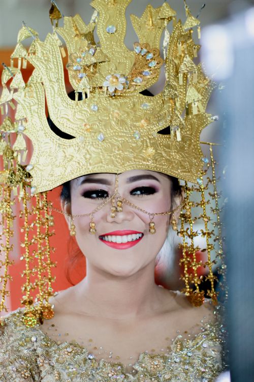 Free Beautiful portrait of a woman wearing an intricate golden crown and traditional attire, radiating joy. Stock Photo