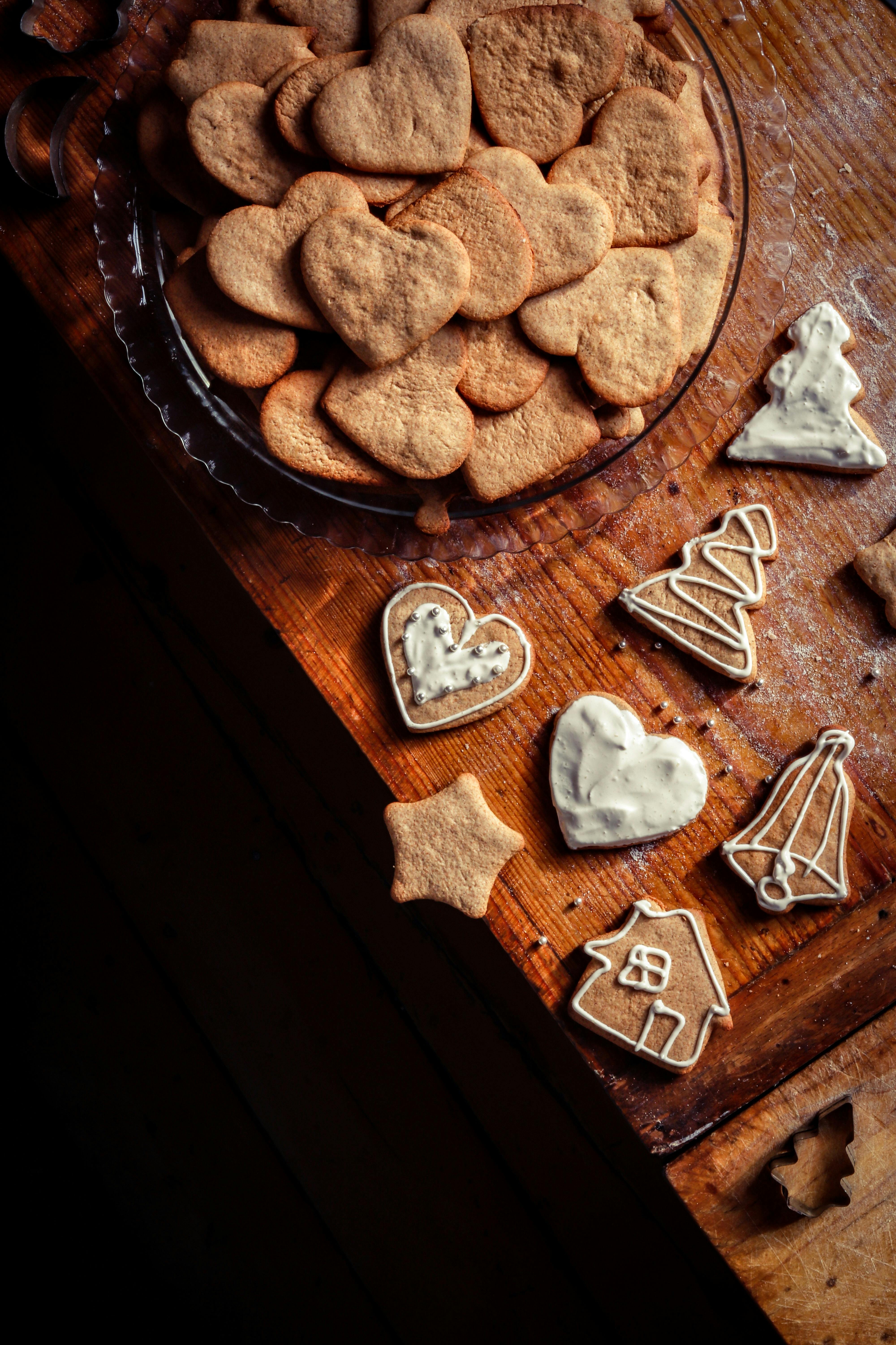 High angle of tasty homemade gingerbread cookies in different forms placed on wooden table at home