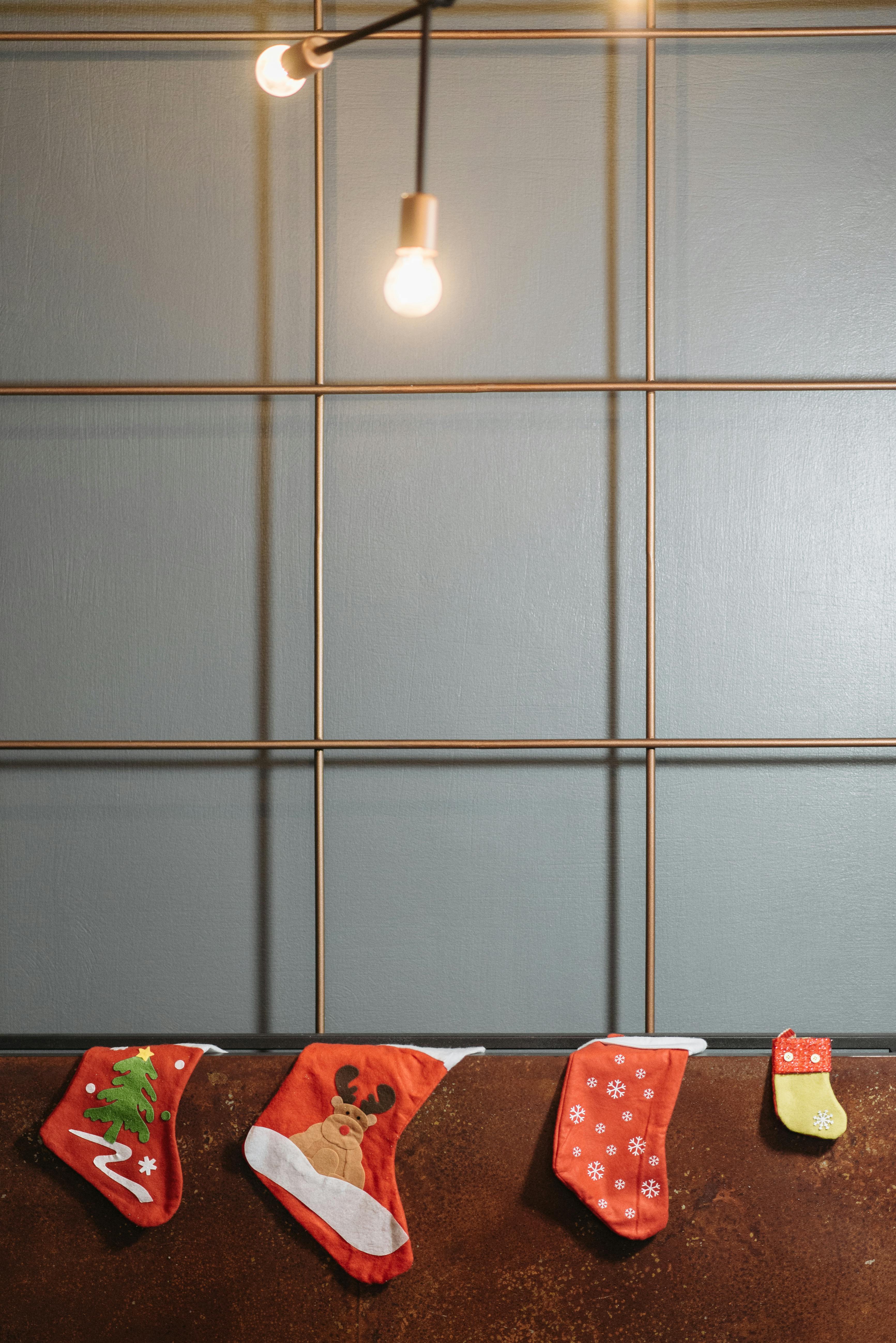 Festive Christmas stockings hanging indoors on a modern wall.