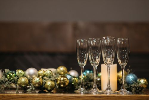 Free Festive Christmas setting with champagne flutes and colorful ornaments. Stock Photo