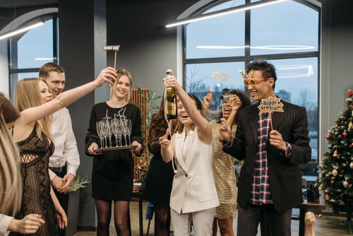 Free Joyful group celebrating New Year with champagne and festive decorations. Stock Photo