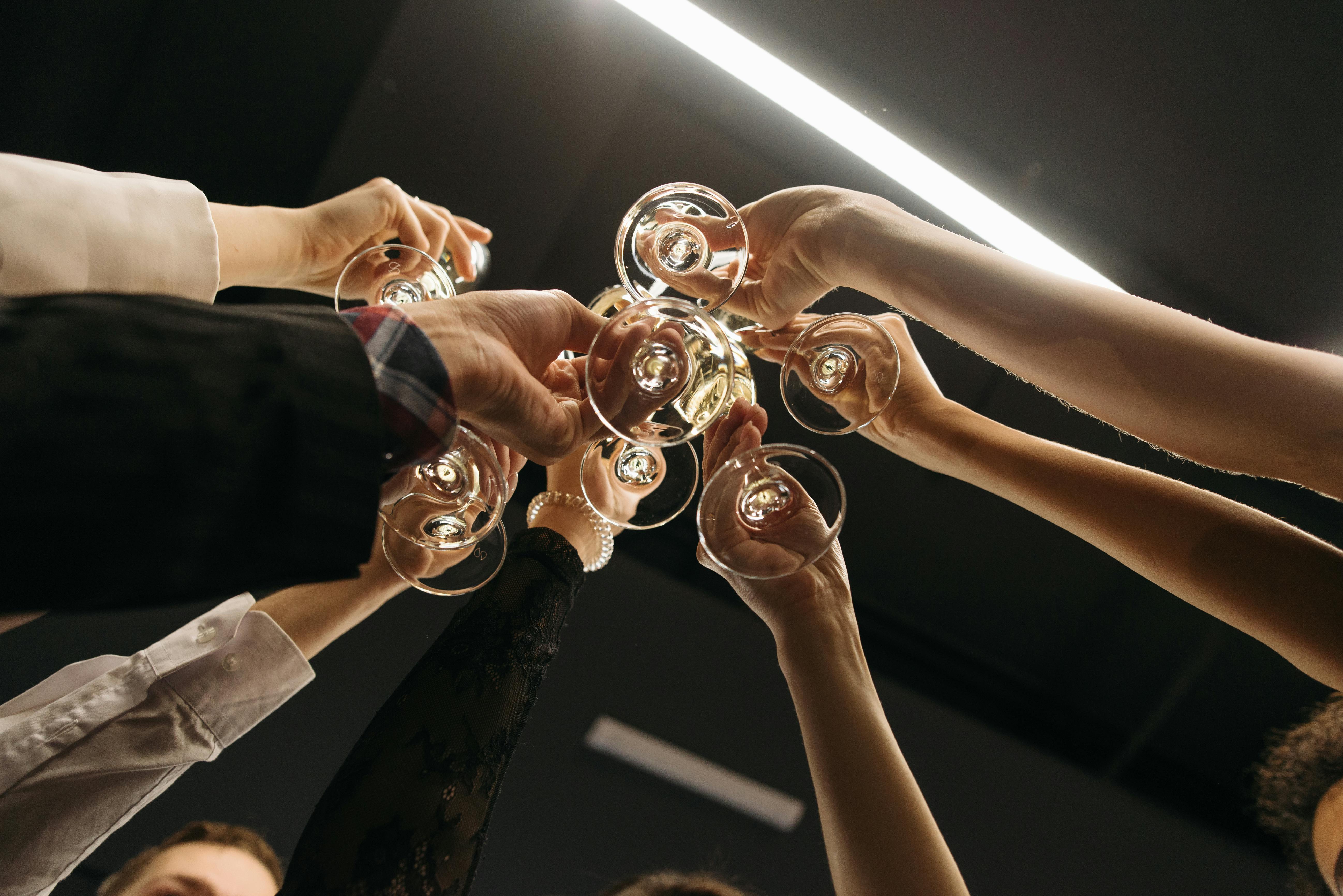 A festive gathering with people toasting with champagne glasses in a low angle shot.