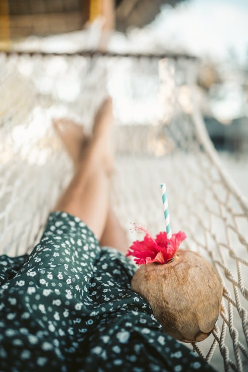 Woman Lying On A Hammock With A Fresh Coconut Juice