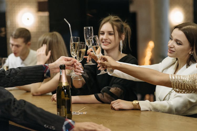 Women Tossing Their Glasses Of Champagne