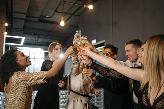A diverse group of colleagues happily toasting with champagne in an indoor setting.