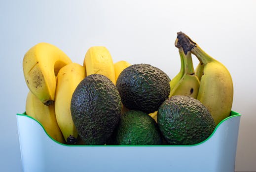 A close-up of ripe avocados and bananas arranged in a basket, perfect for healthy eating.