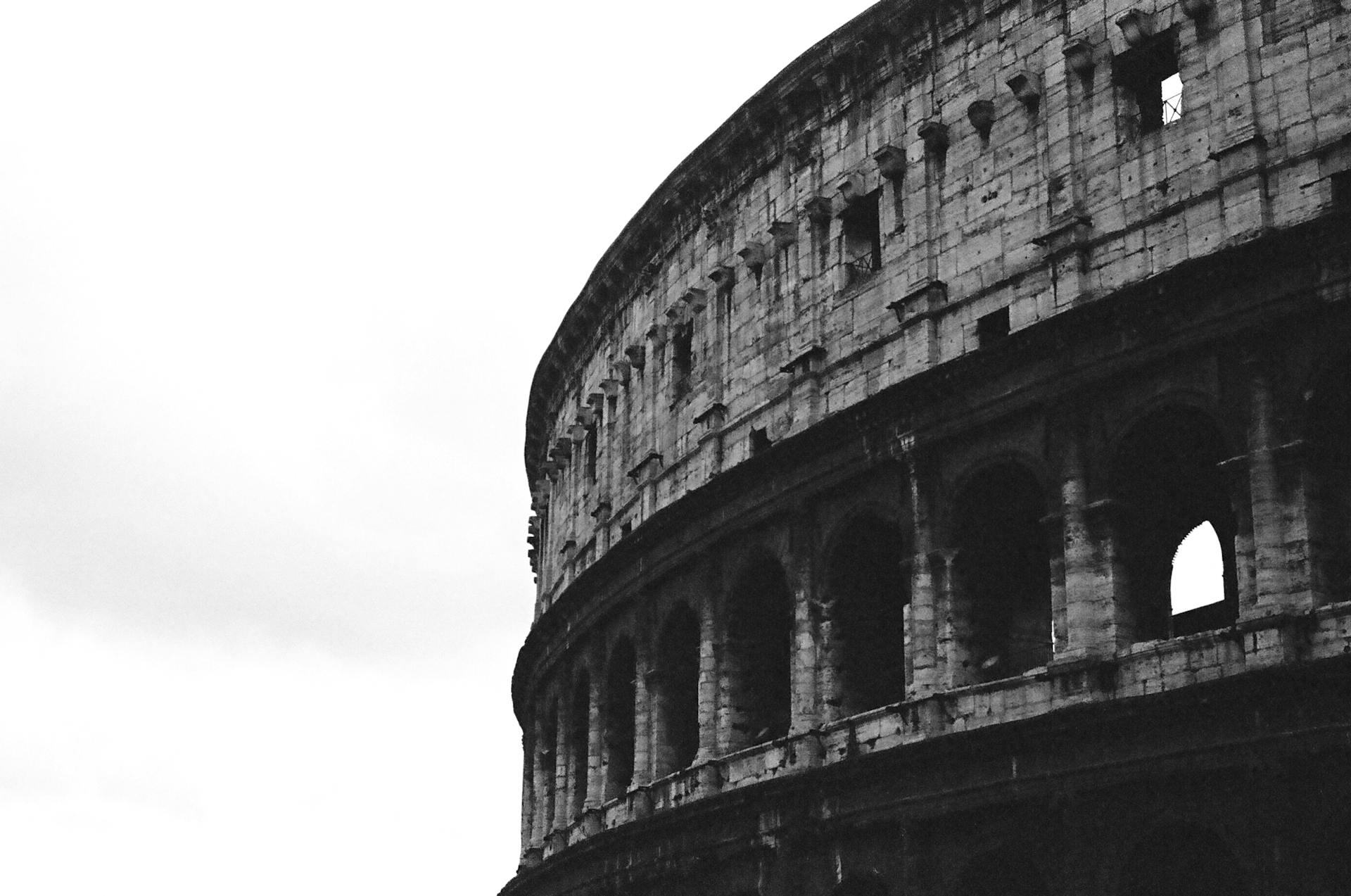 Black and white photo of the Colosseum, capturing its ancient Roman architecture.