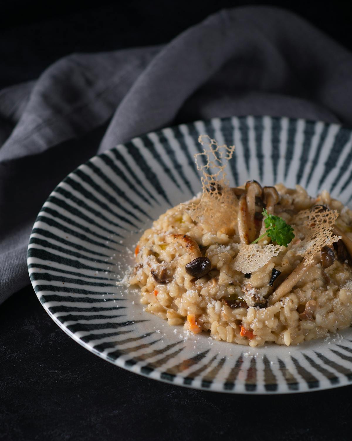 Piatto vicino di risotto cremoso guarnito con erbe