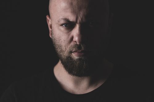 Free Dark and moody close-up portrait of a bearded man with an intense expression. Stock Photo