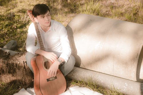 Gratis stockfoto met akoestische gitaar, gitarist, gras