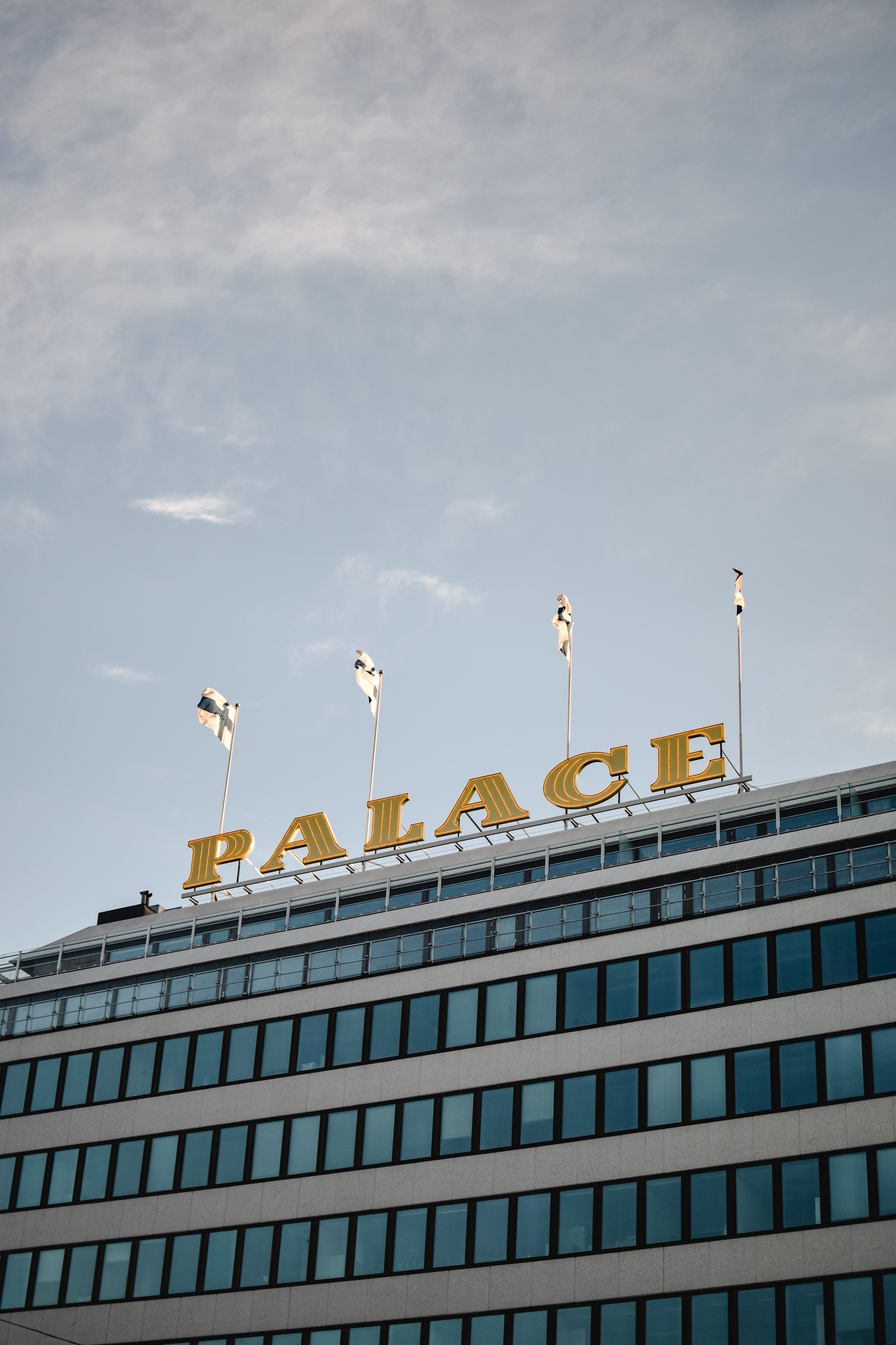 Low angle shot of Palace Hotel in Helsinki with clear blue sky and Finnish flags.