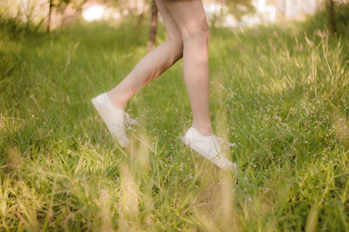 Kostnadsfri bild av ben, gräs, gymnastikskor