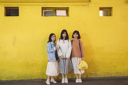 Women Standing in Front of a Yellow Wall