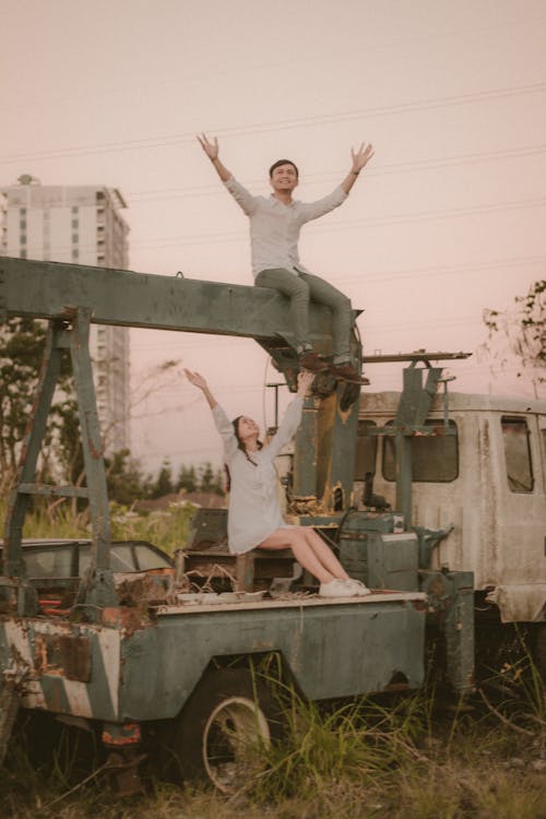Man and Woman Sitting on Derelict Truck