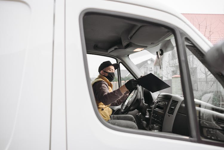 Man In Yellow Vest Holding A Clipboard