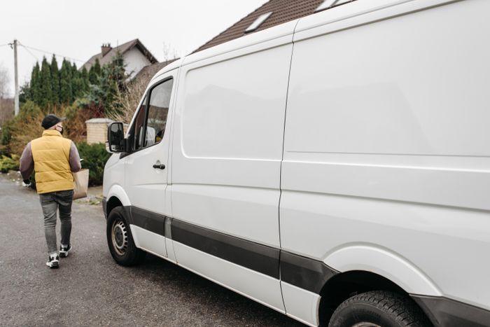A driver walking beside a delivery van