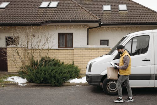 Deliveryman Walking Beside a House