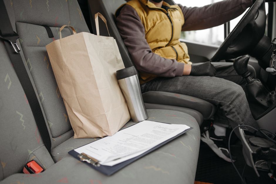 Documents on a car seat next to a driver, similar to the paperwork a car document holder keeps organized