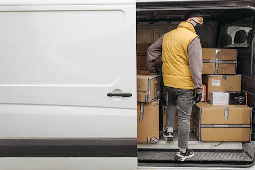 Man Standing Inside a Van with Packages