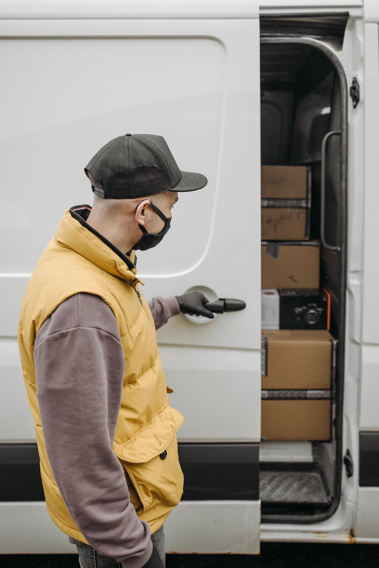 A Deliveryman Opening A Van's Pocket Door