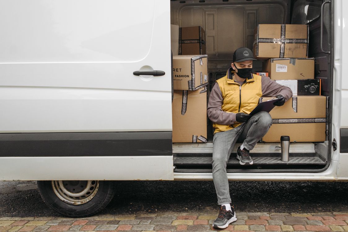 Delivery Rider Behind Lorry A Deliveryman Sitting on the Side of the Van · Free Stock Photo
