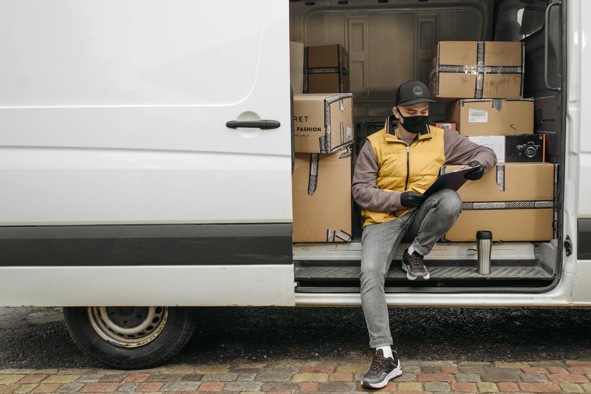 A Deliveryman Sitting on the Side of the Van