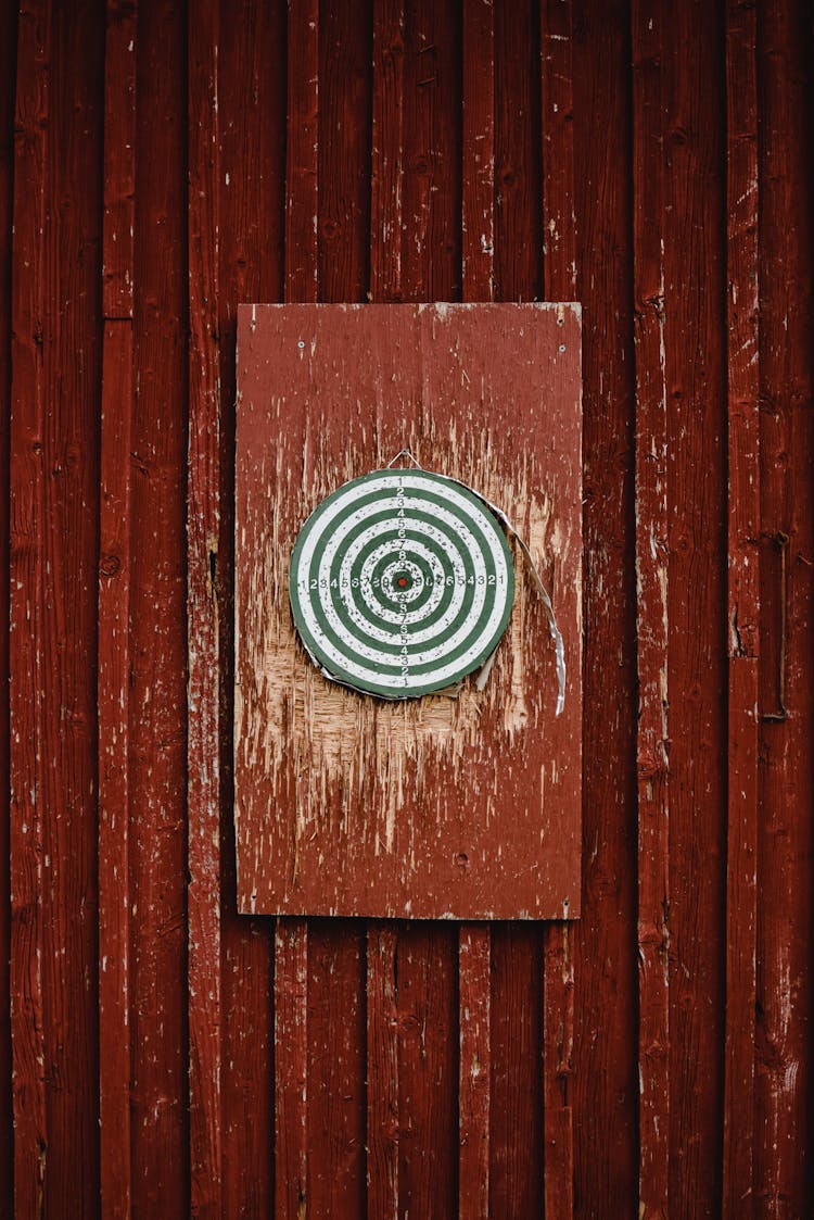 A Dartboard Hanging On A Red Wall