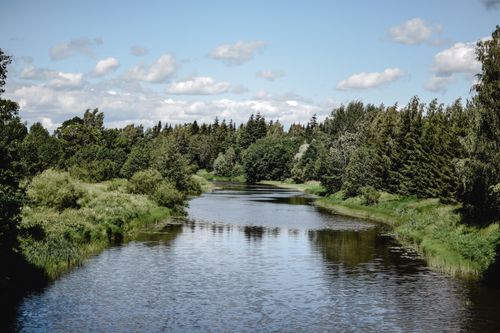 Free Peaceful river view in Helsinki with lush greenery and calm waters under a bright sky. Stock Photo