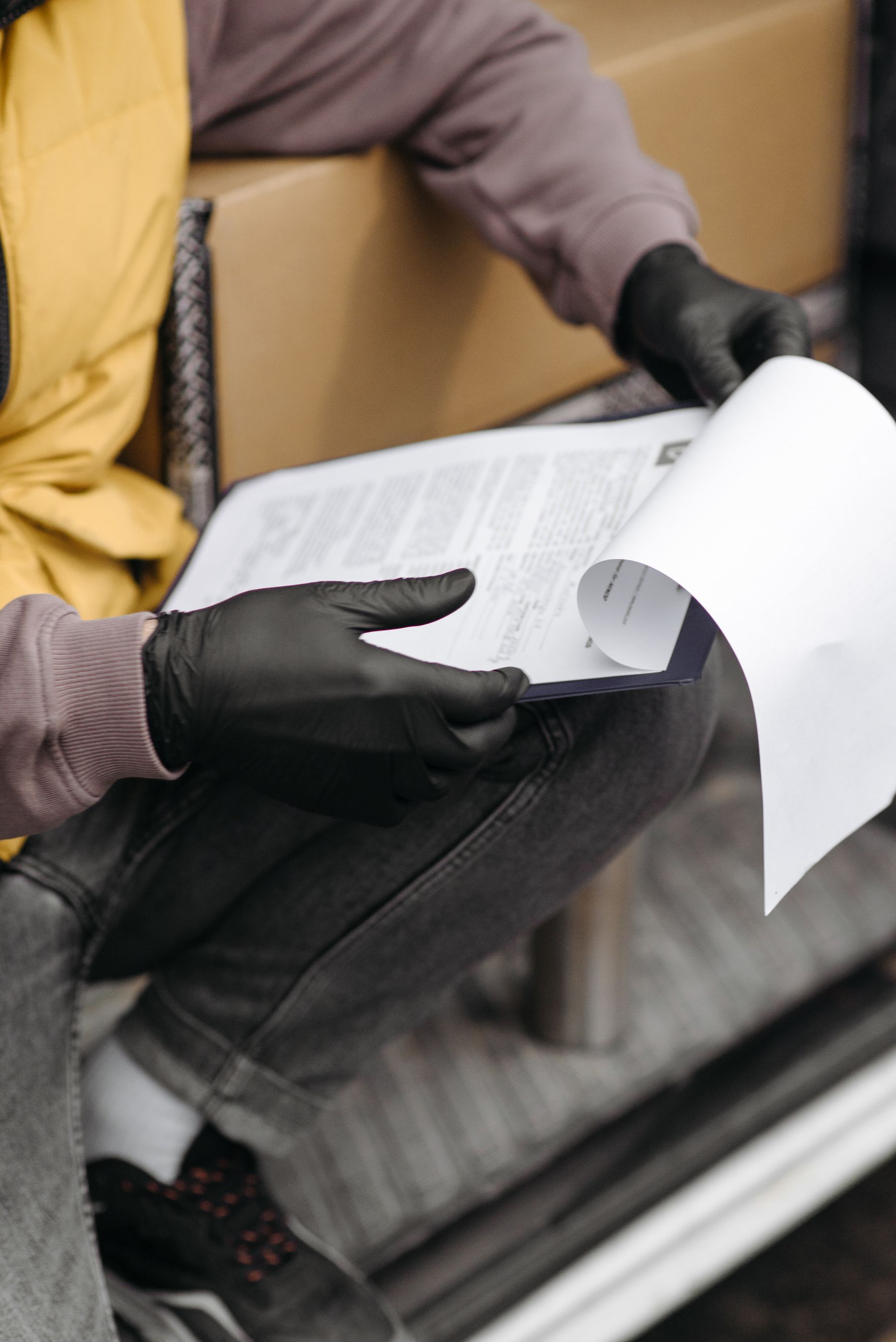 Transportation worker reviewing delivery and compliance paperwork on a clipboard