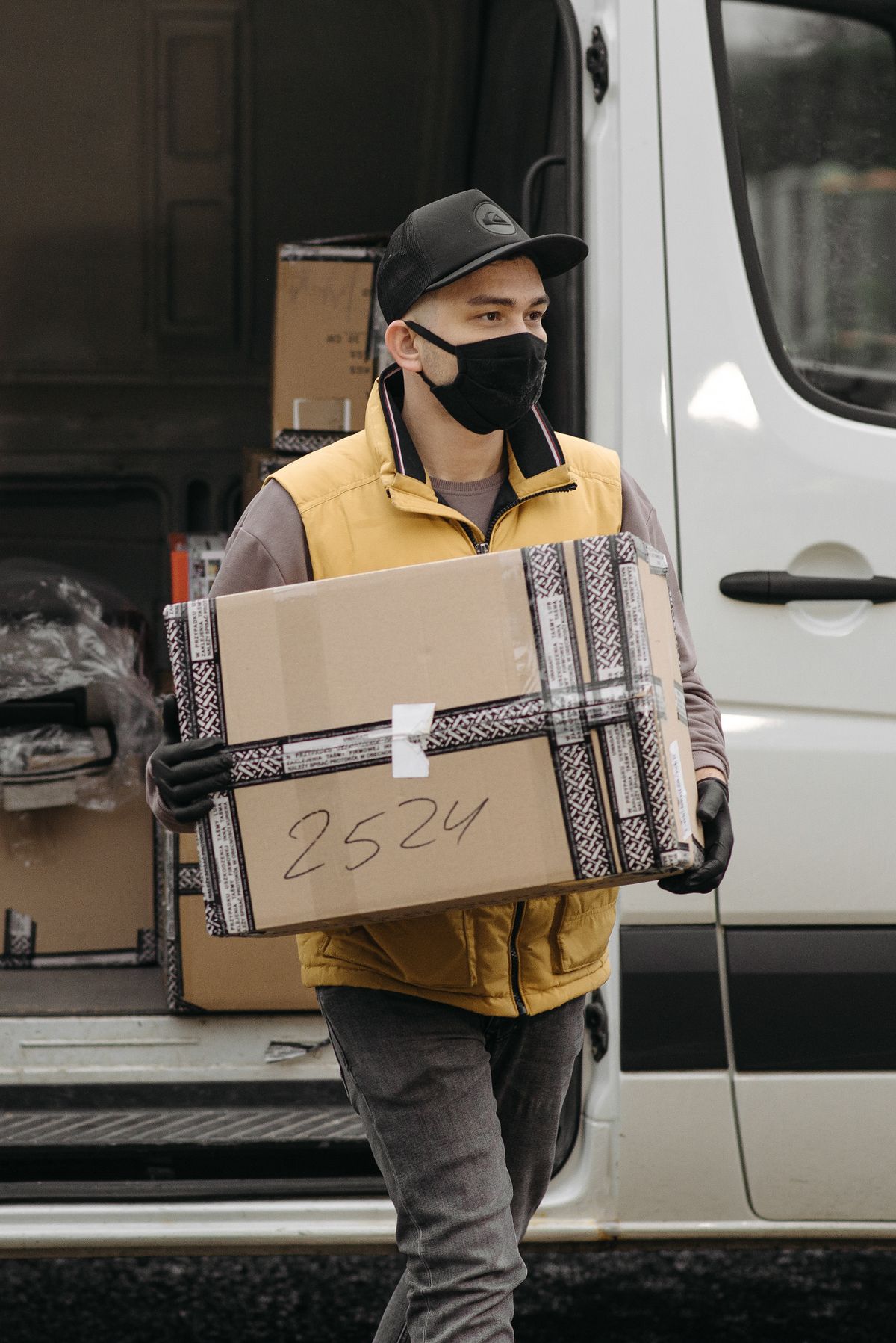 Entregador carregando uma caixa de encomenda, representando um pedido que segue seu fluxo normal até o comprador