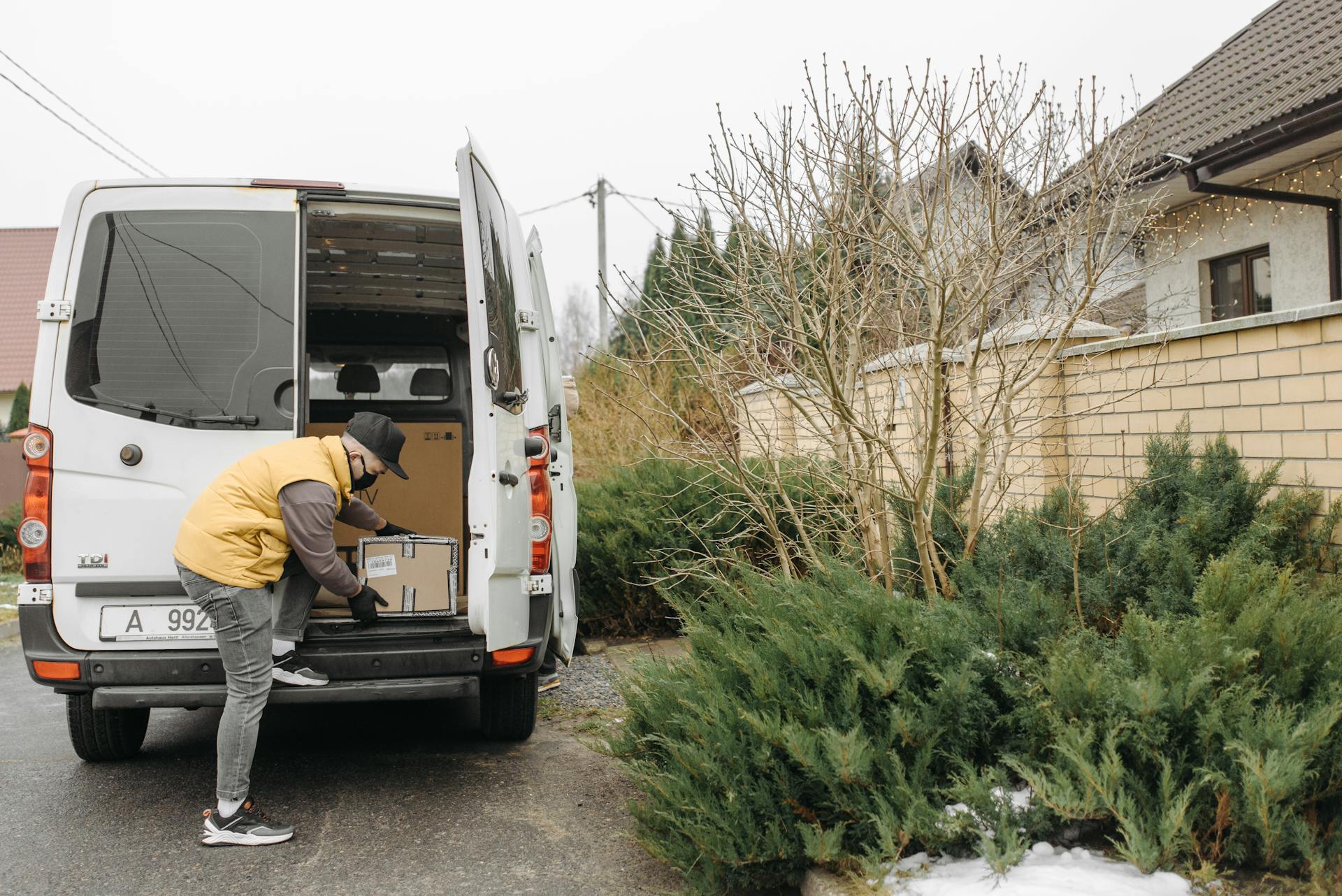 A Deliveryman Taking a Package from Inside the Van